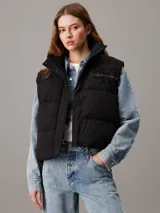 Chaleco puffer negro Calvin Klein Jeans con logo bordado en el pecho, cuello alto, cierre frontal con botones a presión y bolsillos laterales.