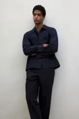 Pantalón de vestir negro de corte recto con cintura elástica y cordón ajustable. Tiene bolsillos laterales y traseros.
