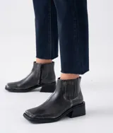 Bota corta negra de cuero con elástico lateral, caña de 12 cm y taco de madera de 4 cm.