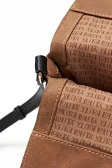 Bolso bandolera color tostado con correa negra y solapa con cierre magnético.