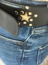 Cinturón negro de cuero con hebilla plateada y apliques de estrellas plateadas.