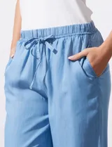 Pantalón ancho de lyocell color celeste, con cintura elástica ajustable con cordón y aberturas laterales en el ruedo con detalle de flecos.