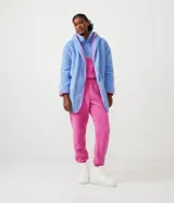Bata de baño en tejido sherpa color celeste con capucha, cierre delantero y mangas largas. Presenta bies contrastante en color rosa.