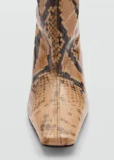 Bota alta color marrón con estampado de piel de serpiente, taco fino y punta fina.