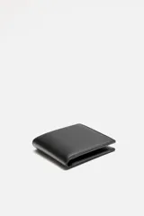 Billetera tipo cartera de corte liso color verde militar. Cuenta con un compartimento para billetes, tres compartimentos para tarjetas y un monedero con cierre mediante clip.