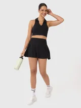 Top deportivo negro con cuello polo y espalda descubierta.