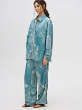 Camisa oversize celeste con estampado tie-dye, bolsillo en el pecho con bordado y terminaciones con ribete en contraste.