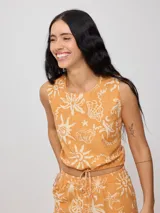 Top corto negro con estampado de flores y figuras geométricas en color crema, con breteles anchos y lazo ajustable en la cintura.