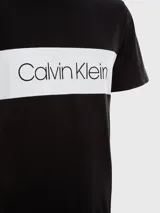 Remera de manga corta Calvin Klein color negro con banda horizontal blanca en el pecho y logo de la marca en color negro sobre la banda blanca.