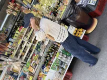 Saco de punto calado color beige claro, con cuello redondo y cierre frontal de botones azules. Presenta detalles decorativos en crochet verde y negro en el frente y puños.