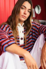 Sweater oversize de punto con rayas horizontales en colores azul, verde y lila. Tiene cuello polo blanco con cartera de botones.