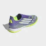 Championes de fútbol Adidas F50 League sin cordones, con exterior Fiberskin y estampado Sprintgrid. El diseño combina colores morado brillante, amarillo neón y blanco. Poseen cuello adaptable, mediasuela de EVA y suela de caucho con taches para césped sintético.