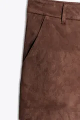 Shorts de tiro alto color negro con textura de gamuza, bolsillos delanteros y cierre frontal con cremallera y ganchos metálicos.