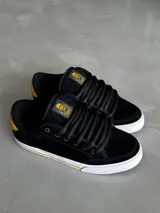 Championes de skate Circa modelo AL 50, color negro con detalles en amarillo y suela blanca.