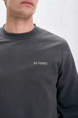 Sudadera gris oscuro de corte clásico con cuello redondo y puños y bajo acanalados. Presenta un pequeño bordado con letras en el pecho.