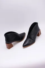 Botines color peltre de cuero con taco de madera y corte en V en el frente.