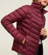 Campera puffer ultraligera color marrón, confeccionada en poliamida acolchada, con cuello alto y cierre por cremallera. Incluye bolsita con cordón.