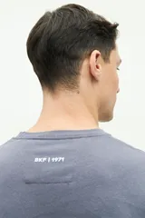 Remera negra de manga corta con bolsillo frontal y logo estampado.