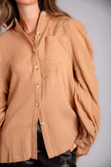 Camisa color beige de muselina con bordado en la parte delantera y manga globo con puño.