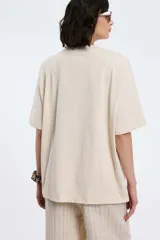 Remera color beige con cuello en V y estampado con la palabra 'Authentic' y una estrella.