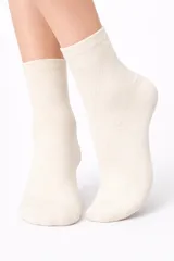 Medias tobilleras de tejido de punto color beige claro, con patrón de rombos calados en relieve.