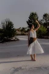 Vestido largo de color blanco, con escote en V pronunciado y tiras largas que permiten anudarlo de múltiples formas. Presenta tajo en ambos laterales y forro interno.