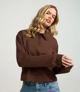 Suéter de manga larga color crema, confeccionado en algodón y poliéster, con cuello polo y tapeta de botones.