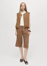 Short de algodón color marrón, con tiro medio, diseño recto, pinzas delanteras y cinturón ajustable. Presenta bolsillos laterales y dos bolsillos de ribete en la parte posterior.