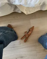 Chatas de cuero vacuno color negro, con punta fina, tira sobre el empeine con hebilla metálica y tira trasera con elástico.