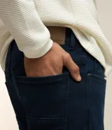 Pantalón de jean azul oscuro, corte slim, con trabillas en la cintura y bolsillos.