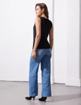 Blusa sin mangas color amarillo, con cuello redondo con frunces delanteros y abertura con botón en la espalda.