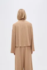 Top color beige de manga larga, holgado y cuello redondo.