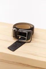 Cinturón marrón con hebilla metálica plateada con diseño de pequeñas esferas.