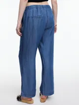Pantalón celeste de pierna recta y calce relajado, confeccionado en denim 100% lyocell con cintura elástica, bolsillos laterales y pespuntes en color contraste.