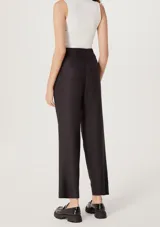 Pantalón negro de corte carrot con cintura alta y pinzas frontales.