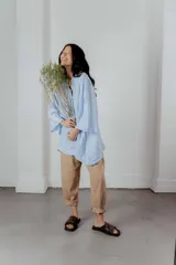 Camisa celeste de lino con escote en V y bordado multicolor en el cuello.