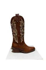 Bota western de cuero color suela, con bordados decorativos en la caña y tacón cubano.
