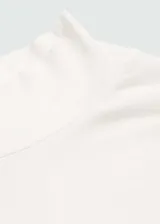 Camiseta blanca de cuello alto y manga larga, corte ajustado.