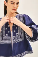 Saco azul marino de algodón con bordados blancos en el frente y mangas 3/4 abullonadas.
