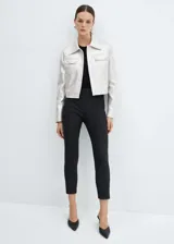 Chaqueta plateada metalizada con cuello camisero, manga larga, diseño recto, cierre frontal con botones y dos bolsillos de solapa en la parte delantera.