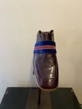 Mocasines de charol color borgoña con banda de terciopelo azul y ribete rojo.