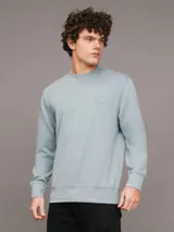 Buzo celeste de cuello redondo, marca Calvin Klein, con logo CK bordado en el pecho.