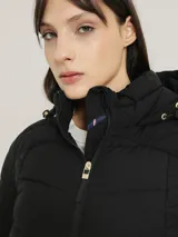 Campera acolchada negra con cierre de cremallera, cuello alto con capucha, mangas largas y bolsillos laterales con cremallera.