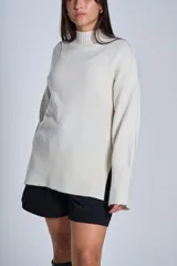 Sweater color crema de media polera, de tejido de punto con detalles acanalados en puños, bajo y cuello.