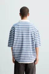 Polo de hombre a rayas horizontales azules y blancas, con cuello clásico blanco y corte relaxed fit.