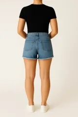 Short de jean color crudo, tiro medio, corte ajustado y ruedo desflecado.