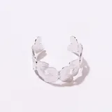 Brazalete abierto de metal plateado con diseño de mariposas en relieve.