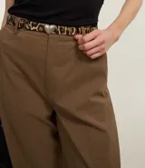 Pantalón de vestir marrón de corte recto, con trabillas en la cintura y estampado de cuadros.