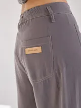 Pantalón negro de pierna ancha con tiro medio alto y pretina elastizada en la espalda. Presenta bolsillos plaque en delantera y espalda.