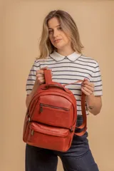 Mochila color marrón de símil cuero con un compartimento principal amplio, bolsillo al frente con cierre, correas ajustables y asa.